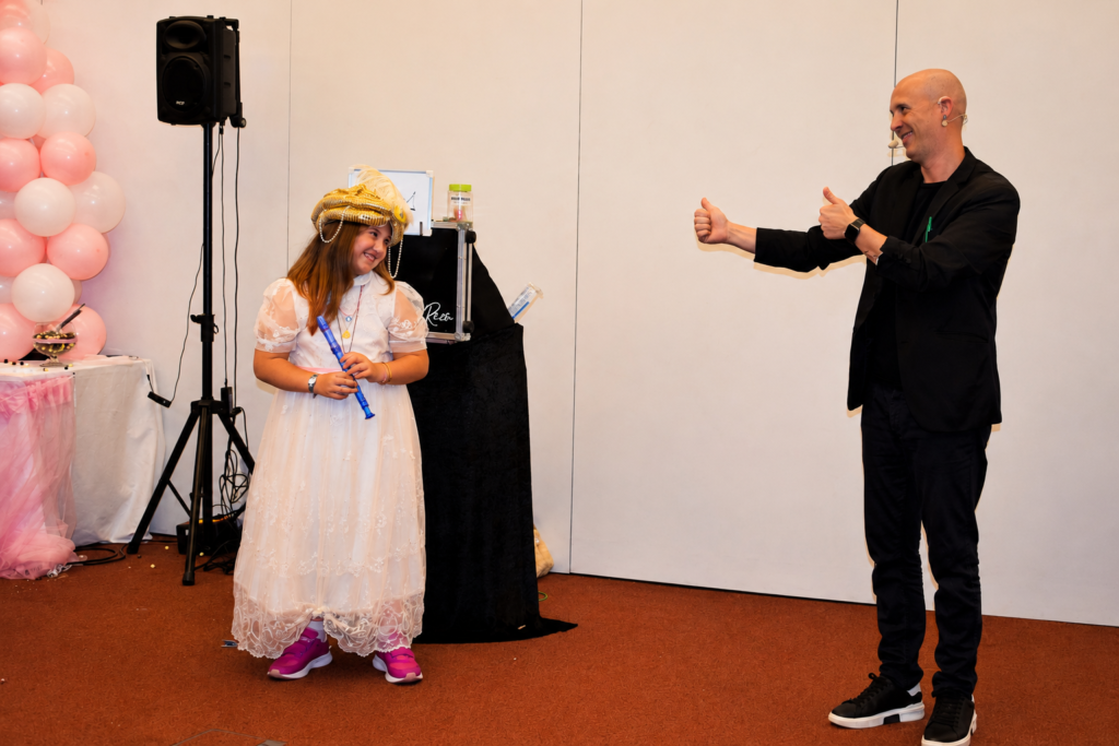 Niña participando en un espectáculo de magia durante su Primera Comunión.