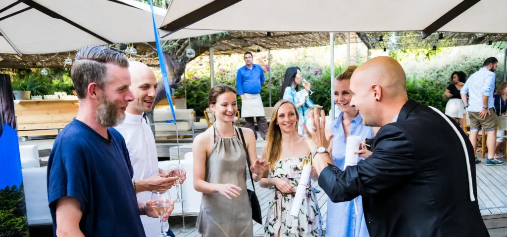 Magia itinerante durante el cóctel de una boda con invitados disfrutando del espectáculo