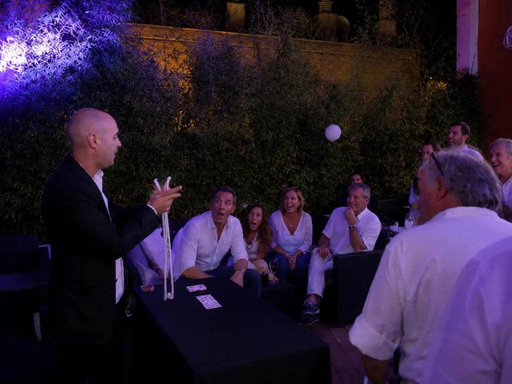 Mago realizando magia de cerca ante un grupo de invitados