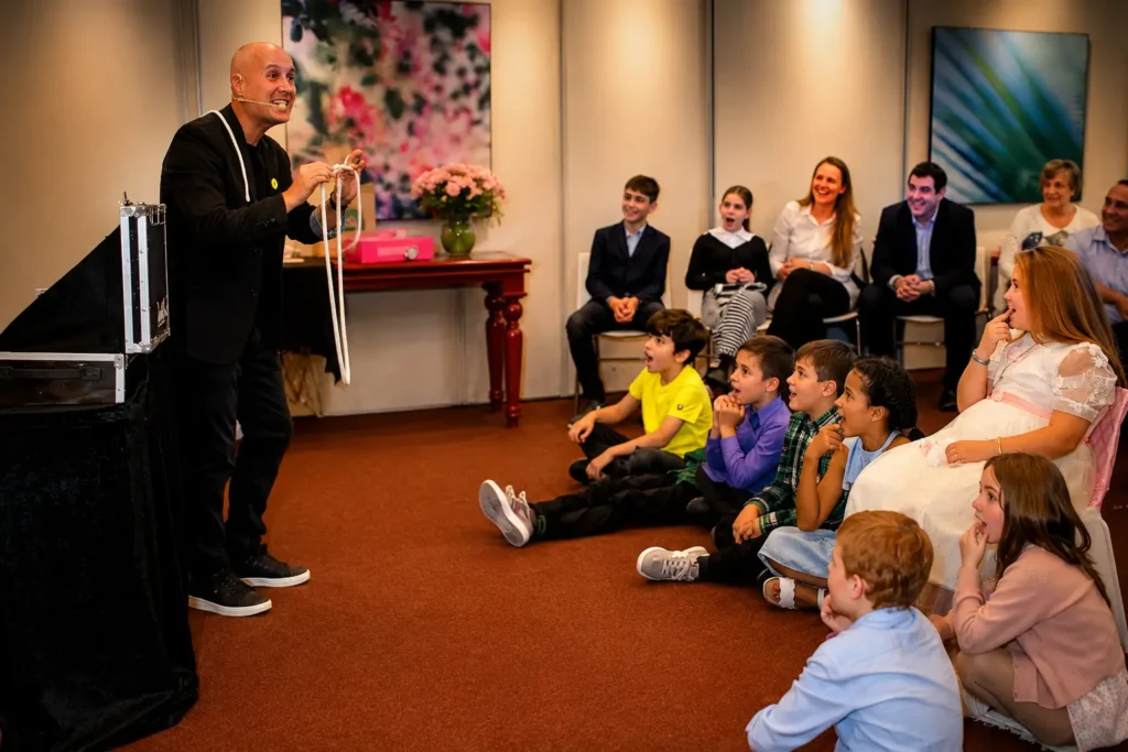 Niños y familiares sorprendidos durante un espectáculo de magia para comuniones en Barcelona.