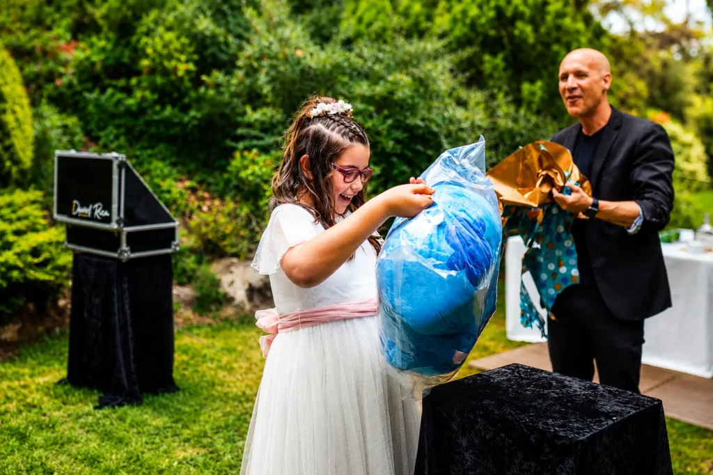 Niña sorprendida al recibir un regalo mágico durante un espectáculo de magia para comuniones.