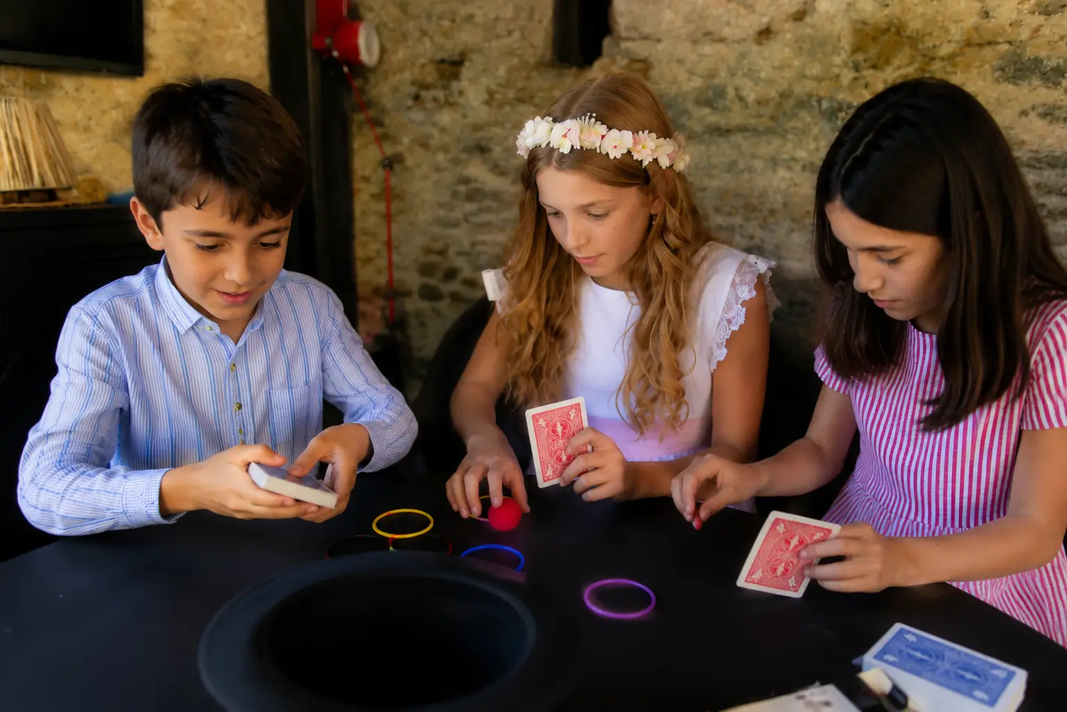 Niños practicando juegos de magia que mejoran la coordinación ojo-mano durante un taller de magia para comuniones.