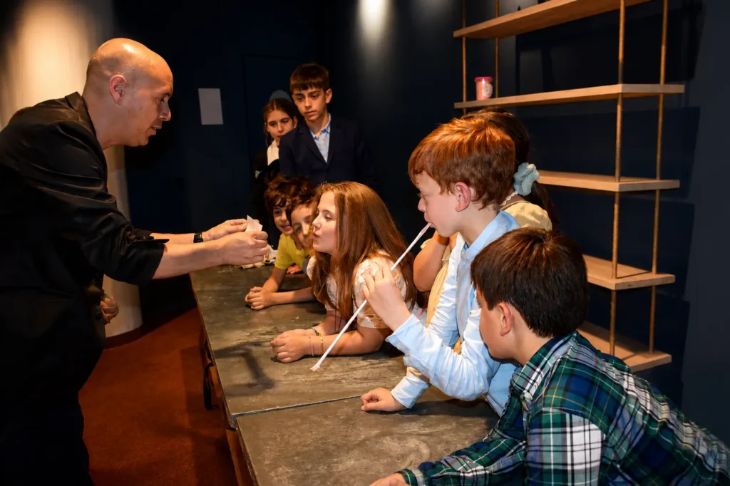 Niños participando en un taller de magia para comuniones mientras aprenden juegos mágicos junto al mago Daniel Reza.